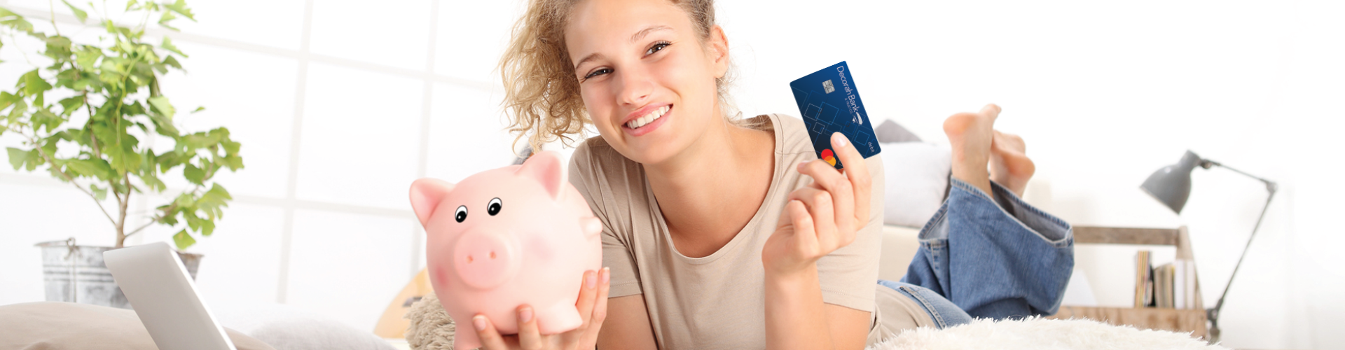 Teen girl with piggy bank and decorah bank debit card